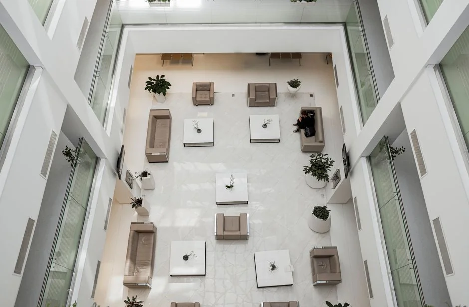 Intérieur de bureau spacieux et moderne avec cloisons vitrées, mobilier élégant et décor mural aux couleurs vives.